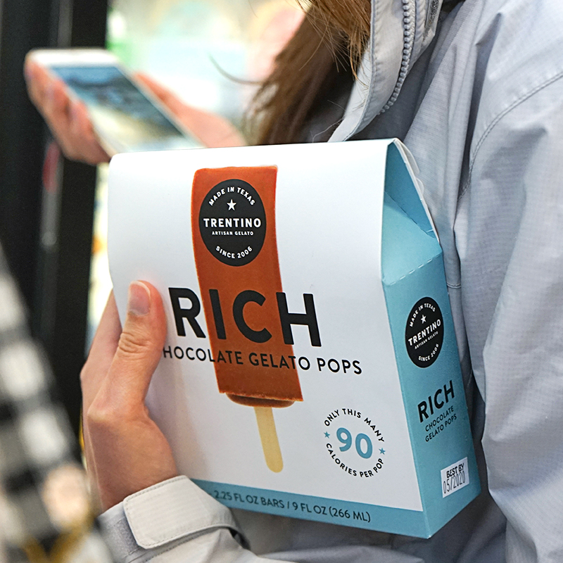 Someone carrying the Rich chocolate Trentino gelato pops box through the store
